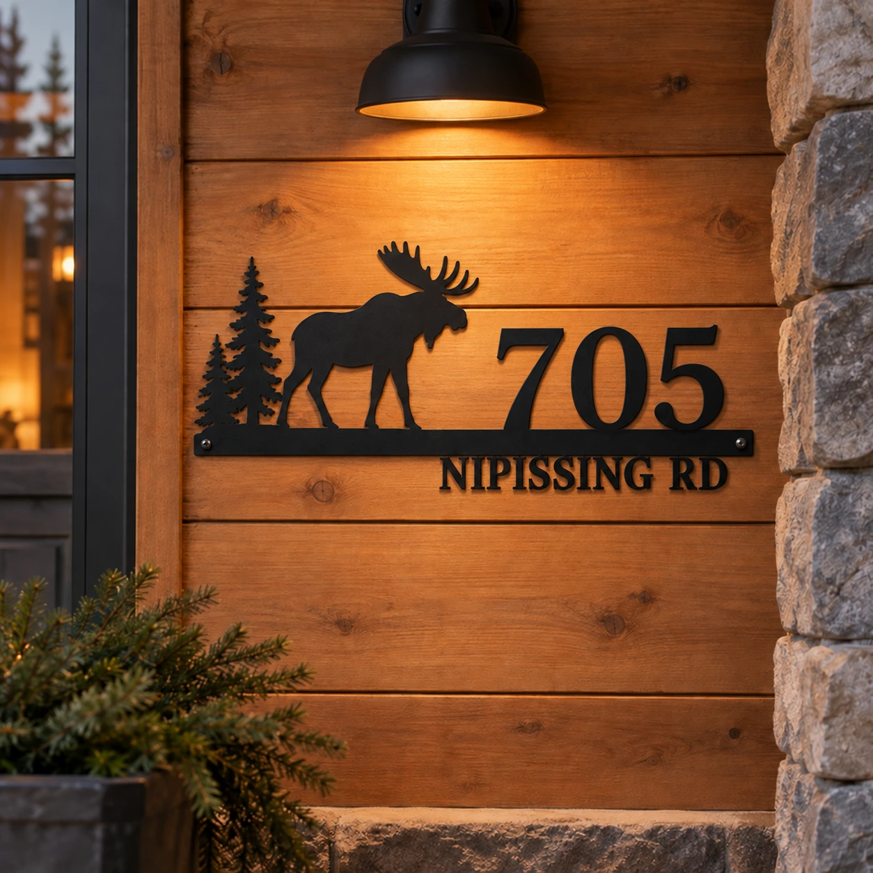 705 Nipissing Road moose and pines metal address sign on a warm timber porch