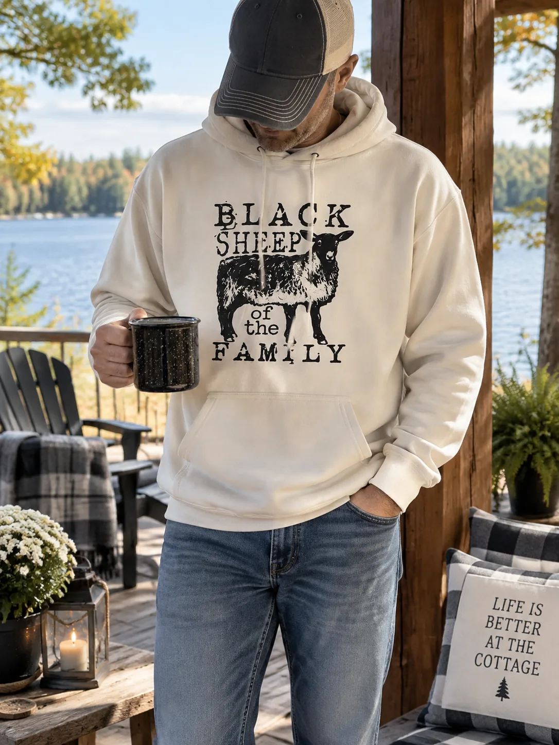 Black Sheep of the Family cream hoodie on a cottage deck